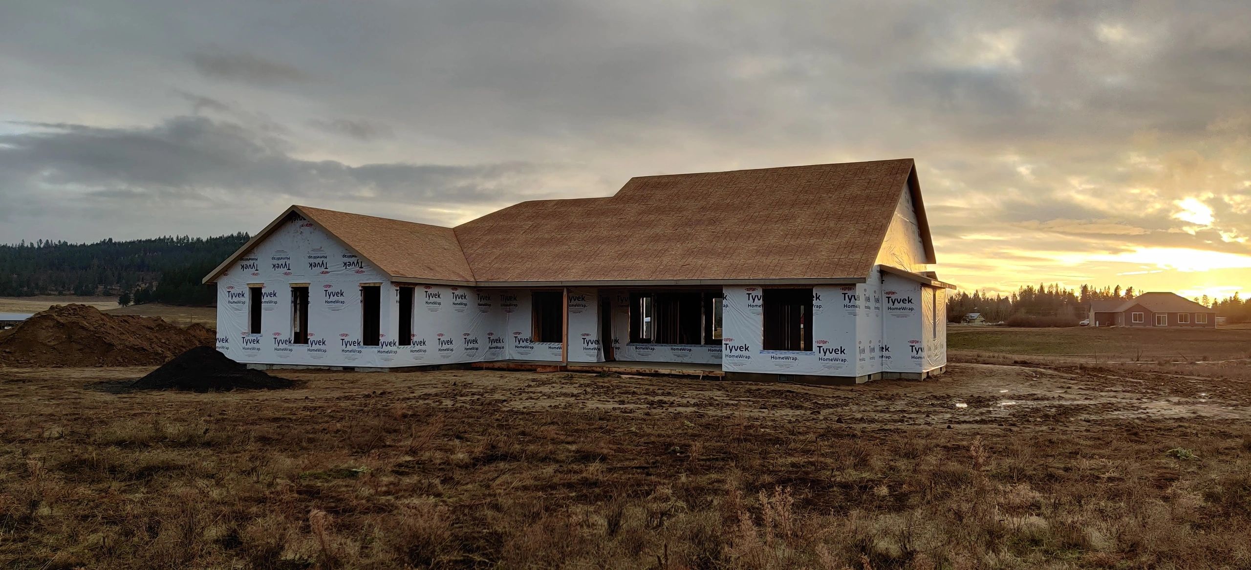 Framed home shell with roof sheathing and exterior walls in progress